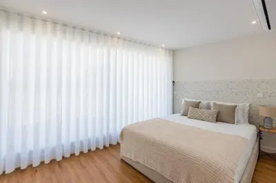 a bedroom with a white bed and a large window at Pestana Apartments - Premium in Porto