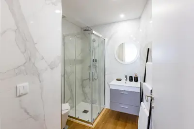 a white bathroom with a shower and a toilet at Pestana Apartments - In city center, Modern, New and Cozy in Porto