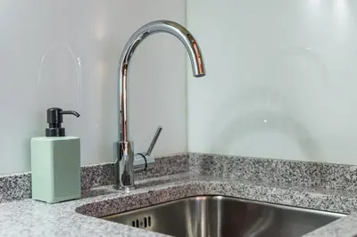 a kitchen sink with a faucet and a soap dispenser at GuestReady - Miragaia Stone Studios & Apartments in Porto