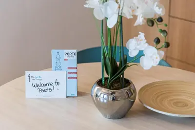 a vase with white flowers on a table with a sign at GuestReady - Miragaia Stone Studios & Apartments in Porto