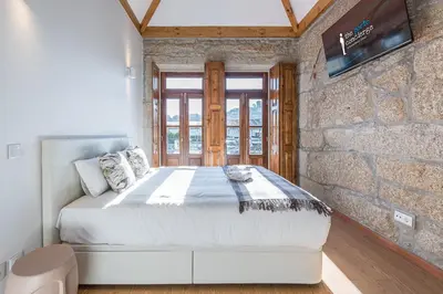 a bedroom with a large bed in a brick wall at GuestReady - Miragaia Stone Studios & Apartments in Porto