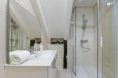 a white bathroom with a shower and a sink at GuestReady - Miragaia Stone Studios & Apartments in Porto