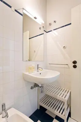 a white bathroom with a sink and a mirror at BOUTIQUE Rentals- P*O*R*T*O Ribeira in Porto