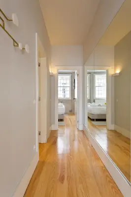 an empty living room with wood floors and a mirror at BOUTIQUE Rentals- P*O*R*T*O Ribeira in Porto