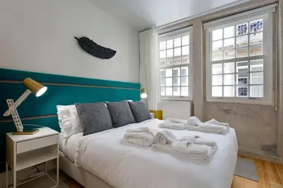 a bedroom with a white bed with towels on it at BOUTIQUE Rentals- P*O*R*T*O Ribeira in Porto