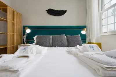 a bedroom with a large bed with white sheets and pillows at BOUTIQUE Rentals- P*O*R*T*O Ribeira in Porto
