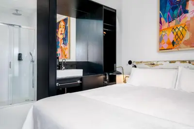 a bedroom with a white bed and a sink at Limehome Porto Rua Das Oliveiras in Porto