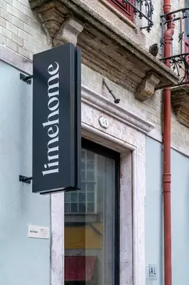 a sign for a store on the side of a building at Limehome Porto Rua Das Oliveiras in Porto