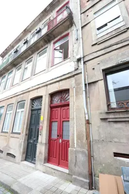 a building with red doors and windows on a street at Rustic Silent Ensuites - Shared Kitchen - Self check in in Porto