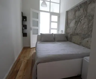 a bedroom with a bed with a stone wall at Rustic Silent Ensuites - Shared Kitchen - Self check in in Porto