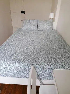 a bed in a small room with a blue bedspread at Rustic Silent Ensuites - Shared Kitchen - Self check in in Porto