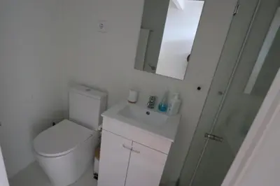 a bathroom with a toilet and a sink and a mirror at Rustic Silent Ensuites - Shared Kitchen - Self check in in Porto