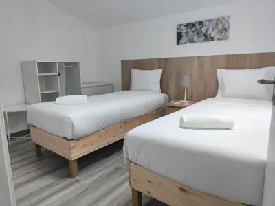 two beds in a room with white sheets at Casa Mini-Ventuzelo by JC in Porto