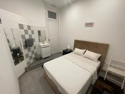 a small bedroom with a white bed and a mirror at Guesthouse Franco in Porto