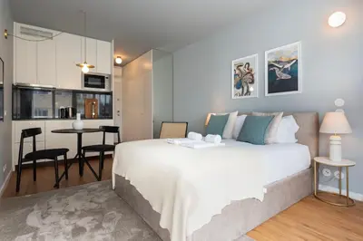 a bedroom with a large white bed and a kitchen at Ceuta 70 by LovelyStay in Porto