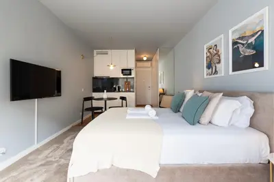 a bedroom with a large white bed with a flat screen tv at Ceuta 70 by LovelyStay in Porto