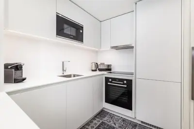a white kitchen with a sink and a microwave at Design Flat in Porto Downtown II in Porto