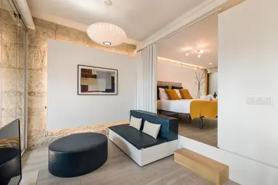 a living room with a fireplace and a table and chairs at Alma das Taipas Apartment in Porto