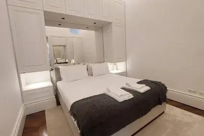 a white bedroom with a bed with two towels on it at Dream on - Clérigos Tower in Porto