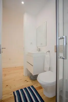 a white bathroom with a toilet and a sink at Liiiving in Porto - Clérigos Terrace Apartment in Porto