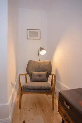 a chair sitting in a room with a lamp at Liiiving in Porto - Clérigos Terrace Apartment in Porto