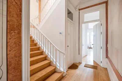 a staircase in a home with white walls and wood floors at MARKES · Lovely 1-bedroom home w/ sunny backyard in Porto