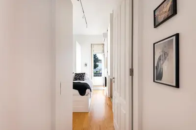 a white hallway with a bed in a room at MARKES · Lovely 1-bedroom home w/ sunny backyard in Porto
