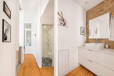 a bathroom with white cabinets and a brick wall at MARKES · Lovely 1-bedroom home w/ sunny backyard in Porto