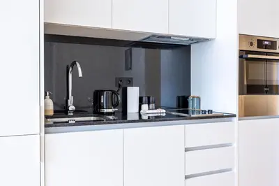 a kitchen with white cabinets and a sink at Aliados luxurious home in Porto