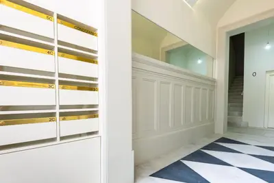 a hallway with white cabinets and a checkered floor at Aliados luxurious home in Porto