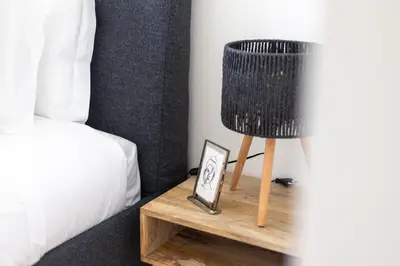 a black lamp on a wooden table next to a bed at Aliados luxurious home in Porto