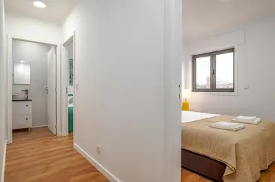 a white bedroom with a bed and a window at Lovely 2BR w/ views over the river, parking incl in Vila Nova de Gaia