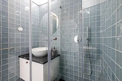 a blue tiled bathroom with a sink and a shower at Ceuta Studio Apartments by LovelyStay in Porto