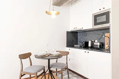 a small kitchen with a table and two chairs at Ceuta Studio Apartments by LovelyStay in Porto