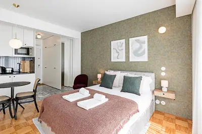 a bedroom with a large bed and a kitchen at Ceuta Studio Apartments by LovelyStay in Porto