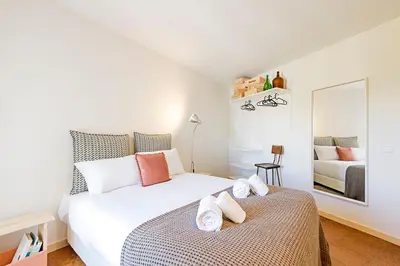 a bedroom with a large white bed and a mirror at Casa 128 by LovelyStay in Porto