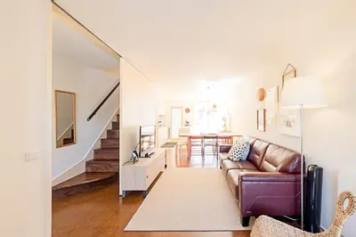 a living room with a brown couch and a staircase at Casa 128 by LovelyStay in Porto