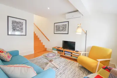 a living room with a blue couch and yellow chairs at Porto Unique Cosy Duplex in Porto