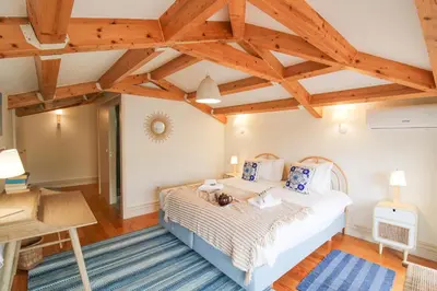 a bedroom with a large bed and wooden ceilings at Porto Unique Cosy Duplex in Porto