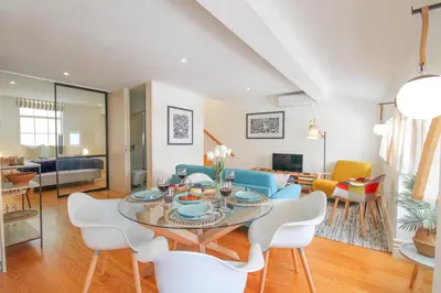 a dining room and living room with a table and chairs at Porto Unique Cosy Duplex in Porto