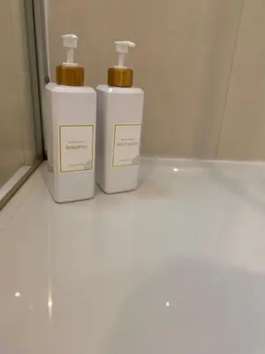 two white bottles ofodorizers sitting on a white floor at We are tourist in Vila Nova de Gaia