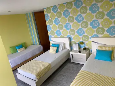 a small room with two beds and a wall with blue at We are tourist in Vila Nova de Gaia