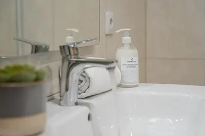 a bathroom sink with a faucet and a bottle of soap at GuestReady - Miragaia Stone Studios & Apartments in Porto