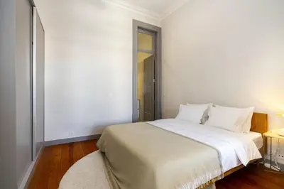 a bedroom with a large bed with white sheets at Stylish Downtown Apartment in Porto