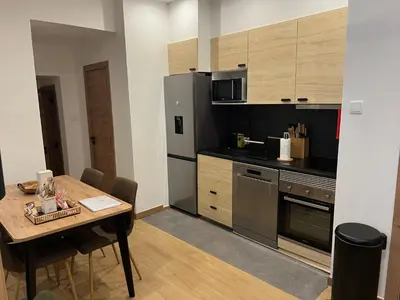 a kitchen with a table and a stainless steel refrigerator at Francisca City House in Vila Nova de Gaia
