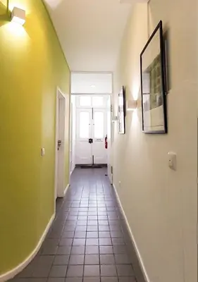 a hallway with yellow walls and a tile floor at PORTO CONCEPT HOME - Campo Alegre in Porto