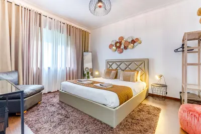 a bedroom with a king sized bed and a chair at Casa da Música Guesthouse in Porto