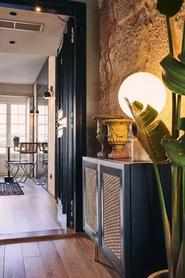 a hallway with a table and a lamp in a room at Prim&Proper in Porto