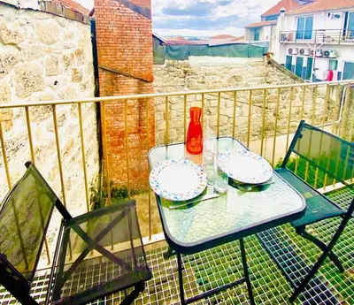 a table with two plates and a bottle on a balcony at Padre António Vieira flat E - 2 Bedroom Near Campanhã train station in Porto