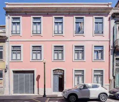 a pink building with a car parked in front of it at Boutique Rentals-Primrose Terrace&Garage in Porto